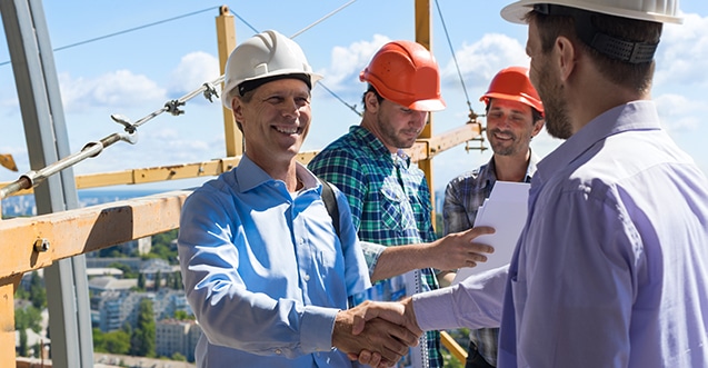 Professional roof inspection expert shaking hands with business owner