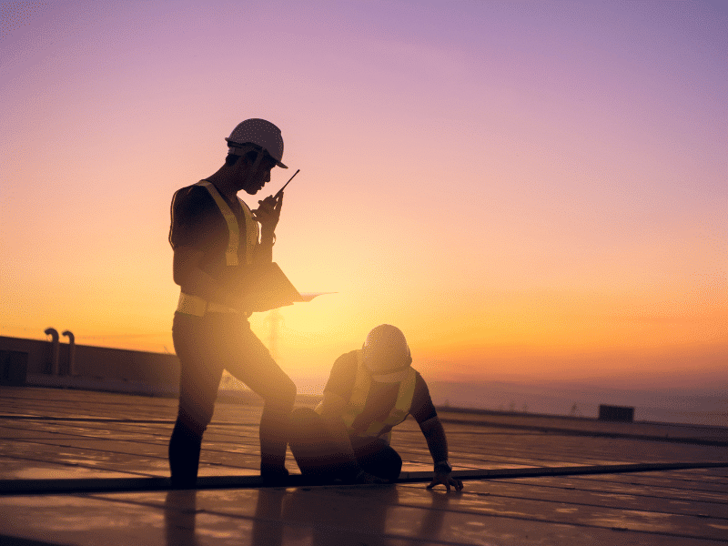two men performing roof maintenance.